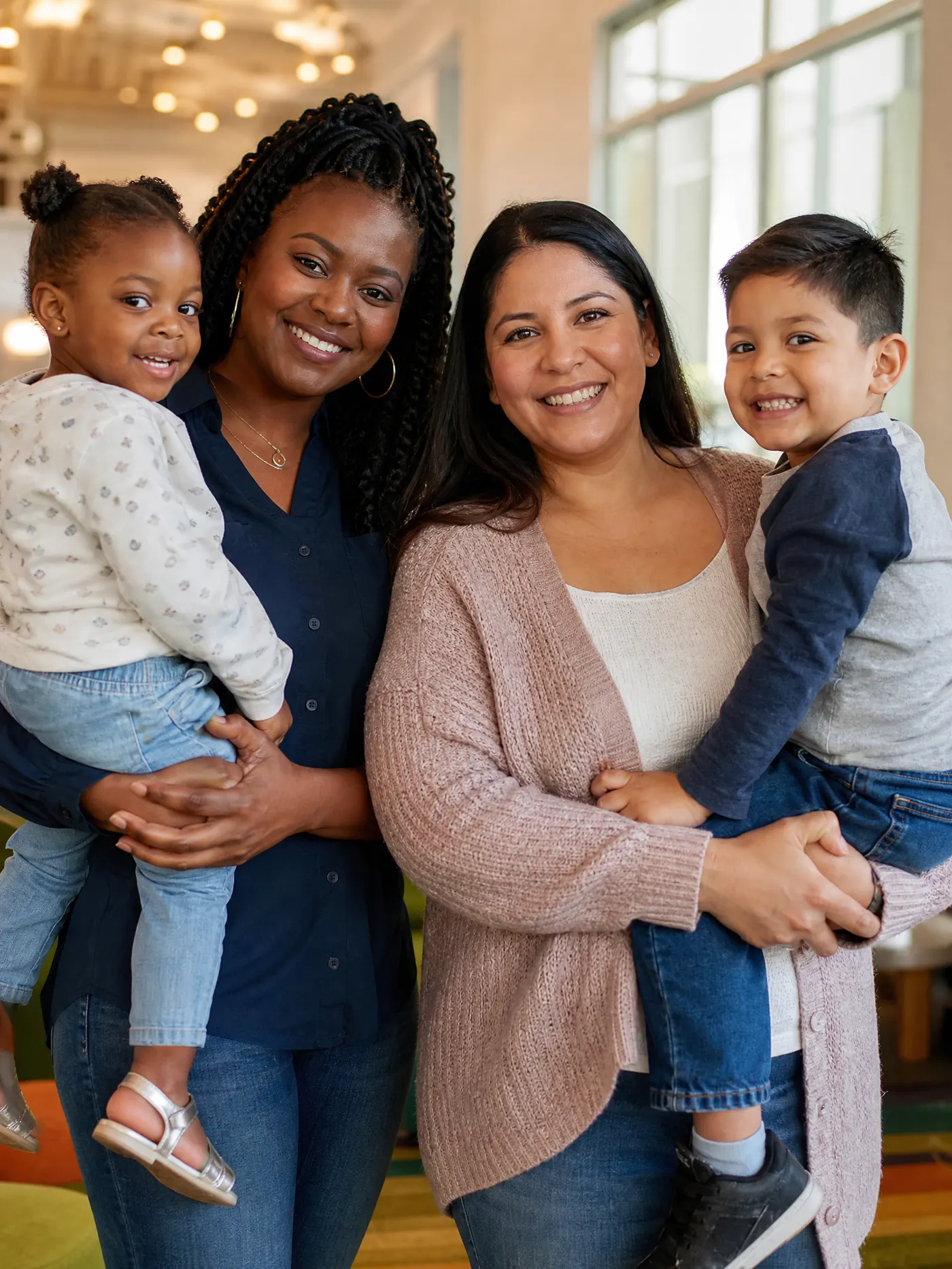 Two mothers with their children, representing families served by the foundation